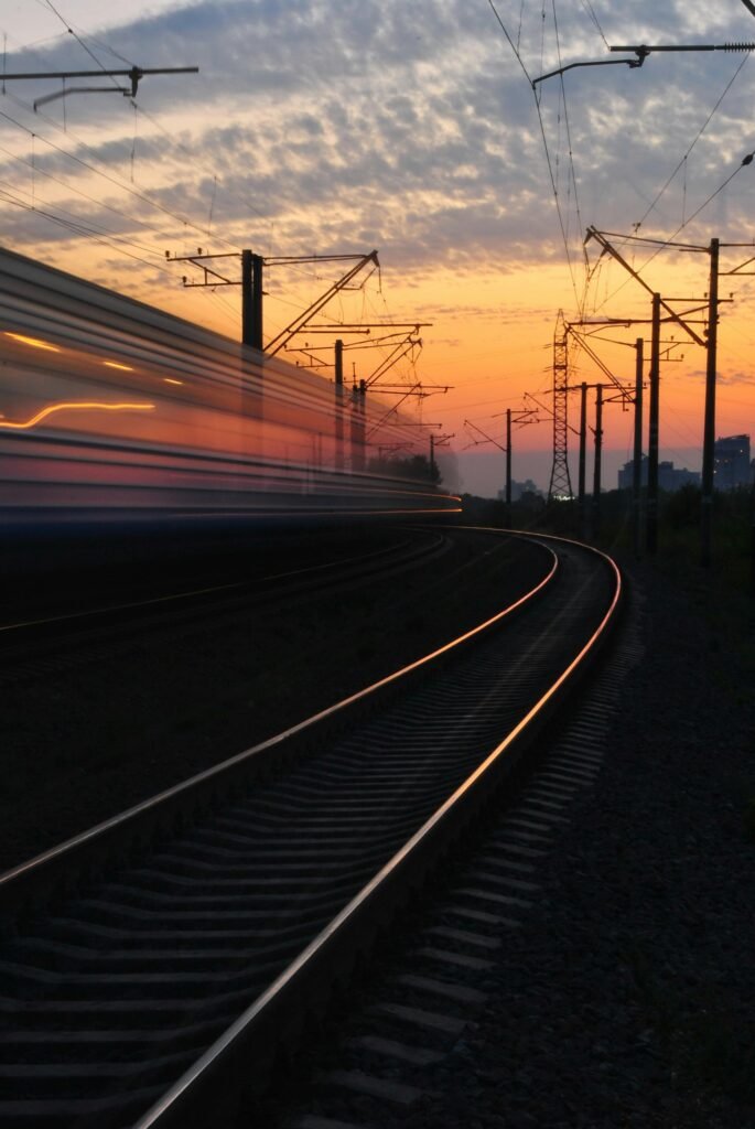 sunset-train-road-163856-163856 A dynamic shot capturing a blurred train speeding on curved tracks during a vibrant sunset.